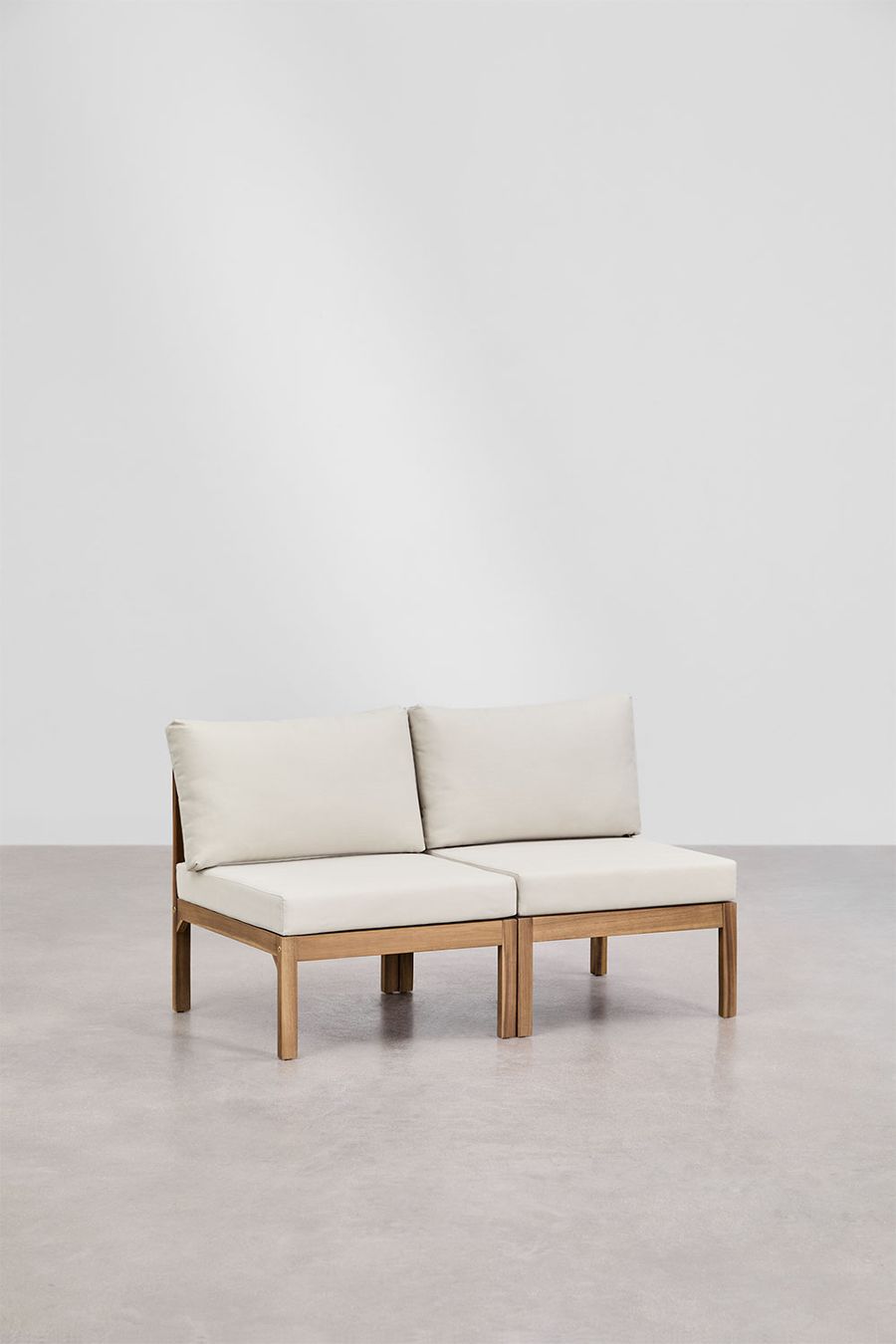 Canapé Branson à deux modules en bois d'acacia et coussins crème, posé sur un sol béton clair.