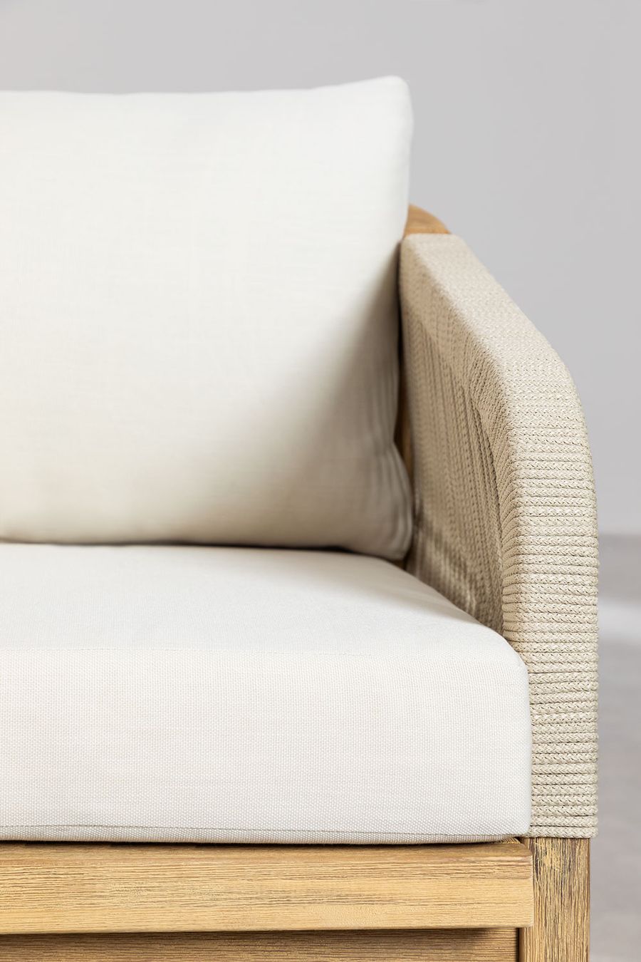 Gros plan d'un coussin blanc et de l'accoudoir en cordage beige du canapé Dubai.
