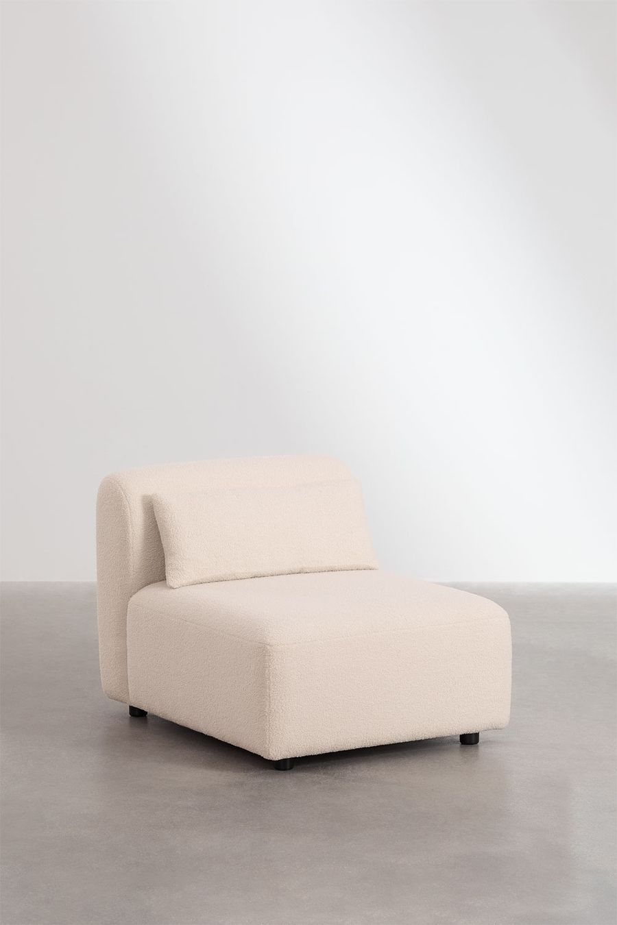 Module d'assise du canapé Fogler en tissu bouclé beige, avec un coussin de dossier, vu de trois quarts.
