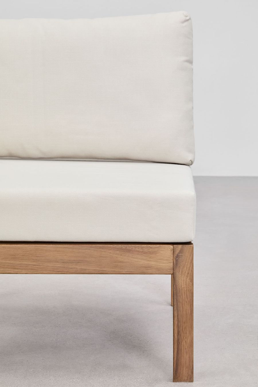 Gros plan d'un accoudoir ou d'un coussin crème et d'un pied en bois d'acacia du canapé Branson.