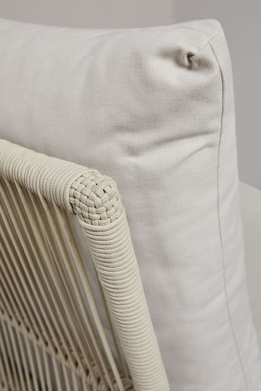 Gros plan d'un coussin écru et de la tresse de cordage au bord d'un accoudoir du canapé Dailin.