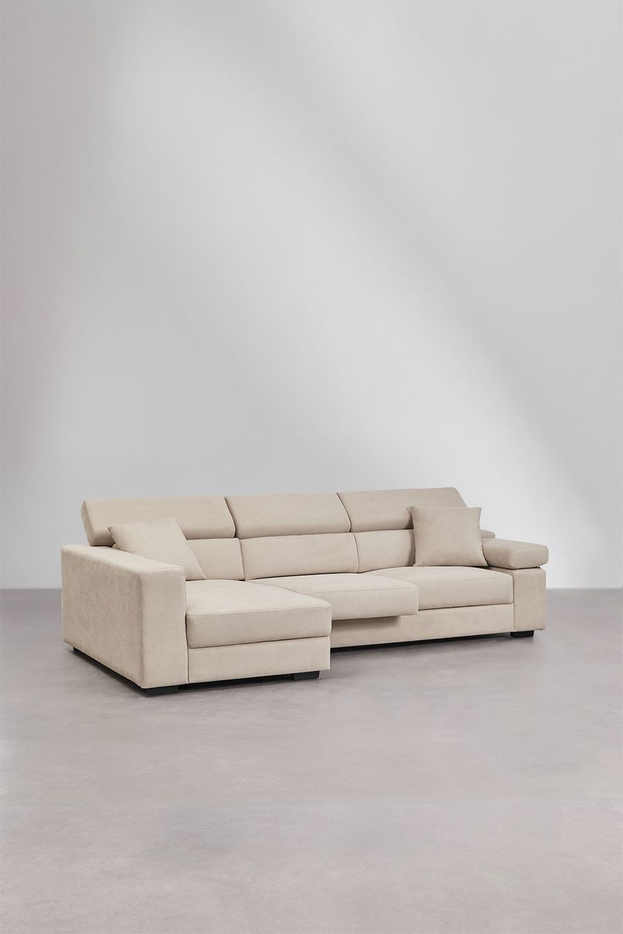 Canapé Aramis beige d'angle vu de trois quarts, méridienne à gauche, sol gris.