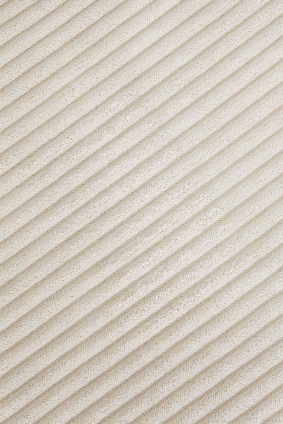 Gros plan du velours côtelé beige crème du canapé Tampere en diagonale.