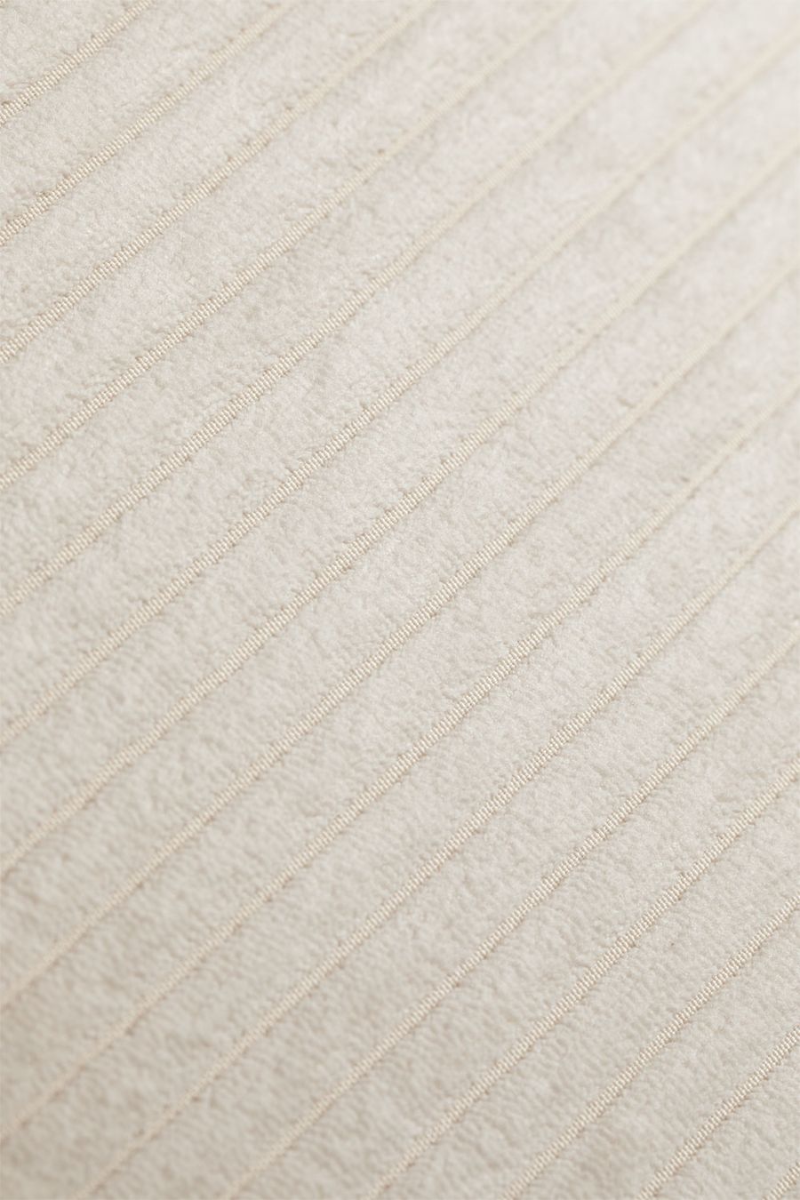 Gros plan du tissu beige clair du canapé Paoly, avec de fines côtes en diagonale.