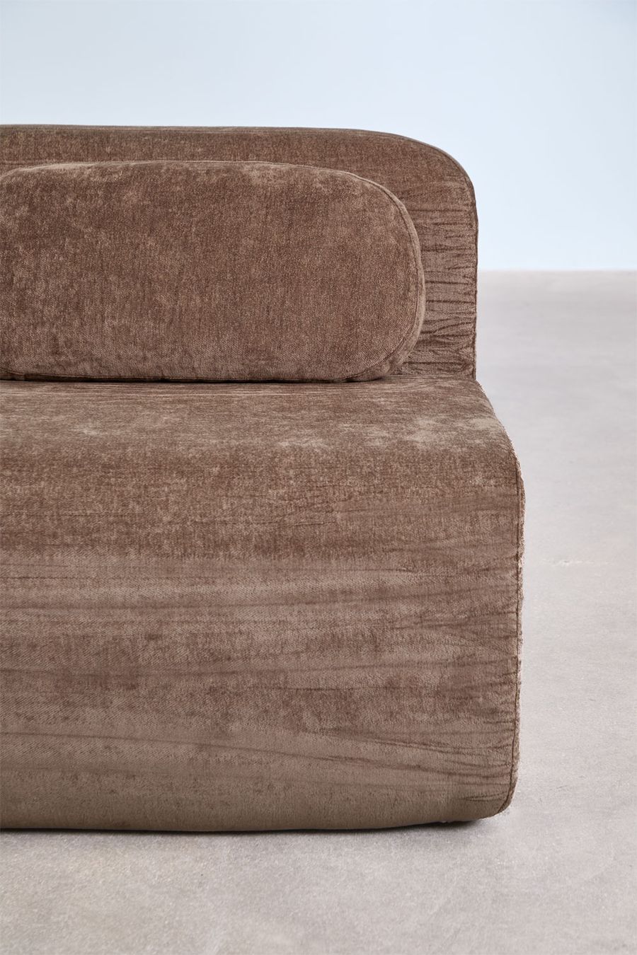 Gros plan sur le module Merida brun avec son coussin cylindrique et le revêtement chiné.