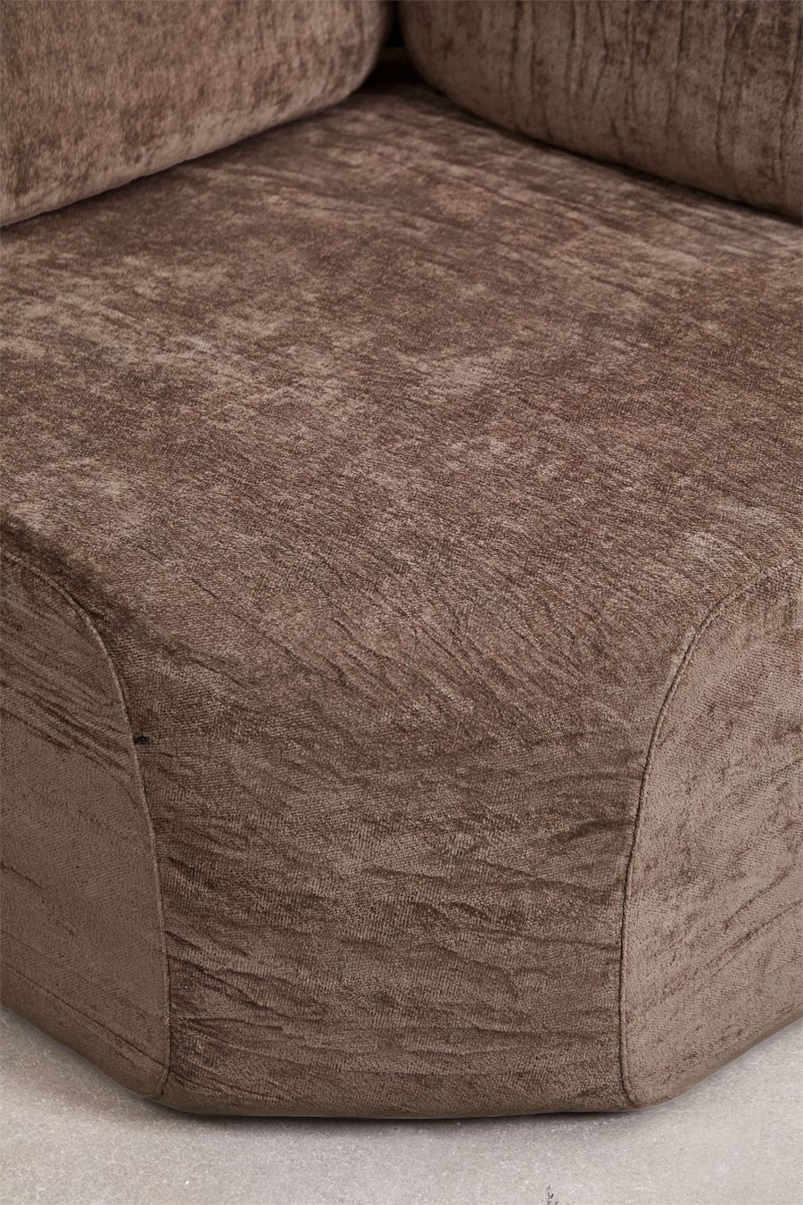 Gros plan sur l'assise du module d'angle Merida brun en chenille froissée.