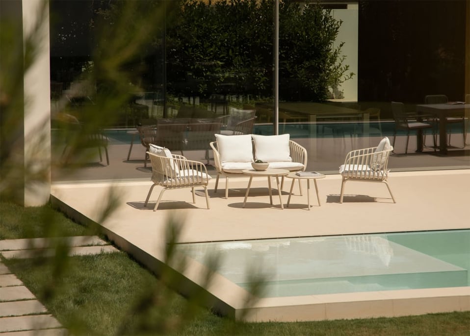 Gartenset mit einem 2-Sitzer-Sofa, 2 Sesseln und 2 Couchtischen aus Eisen und Aradina-Polypropylen.