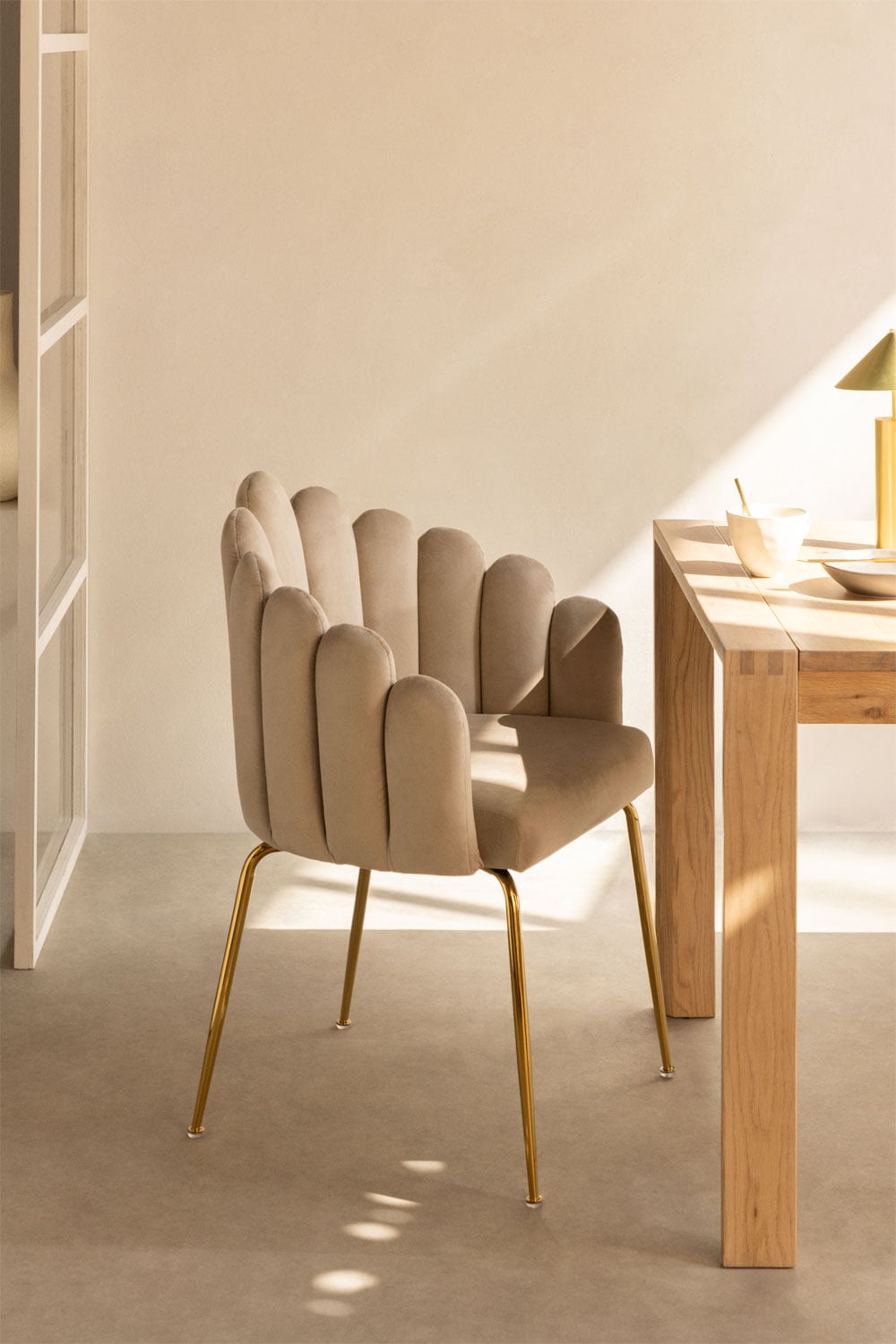 Silla de comedor tapizada en terciopelo beige con patas doradas