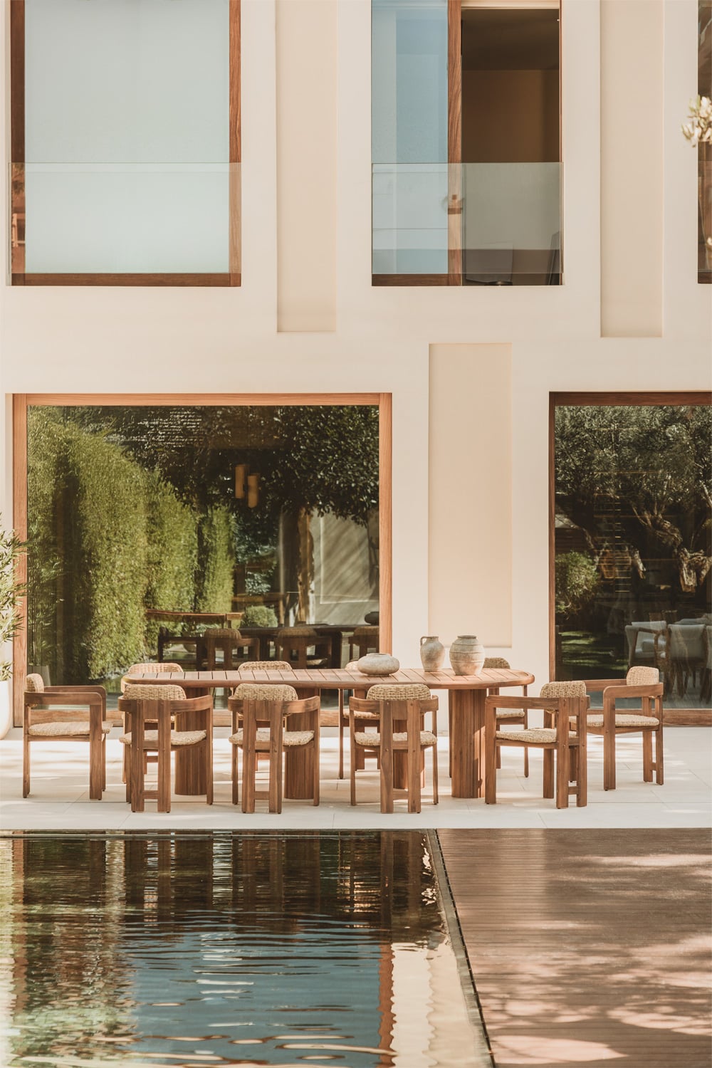 Set de comedor exterior con mesa ovalada de acacia y 10 sillas Ginara