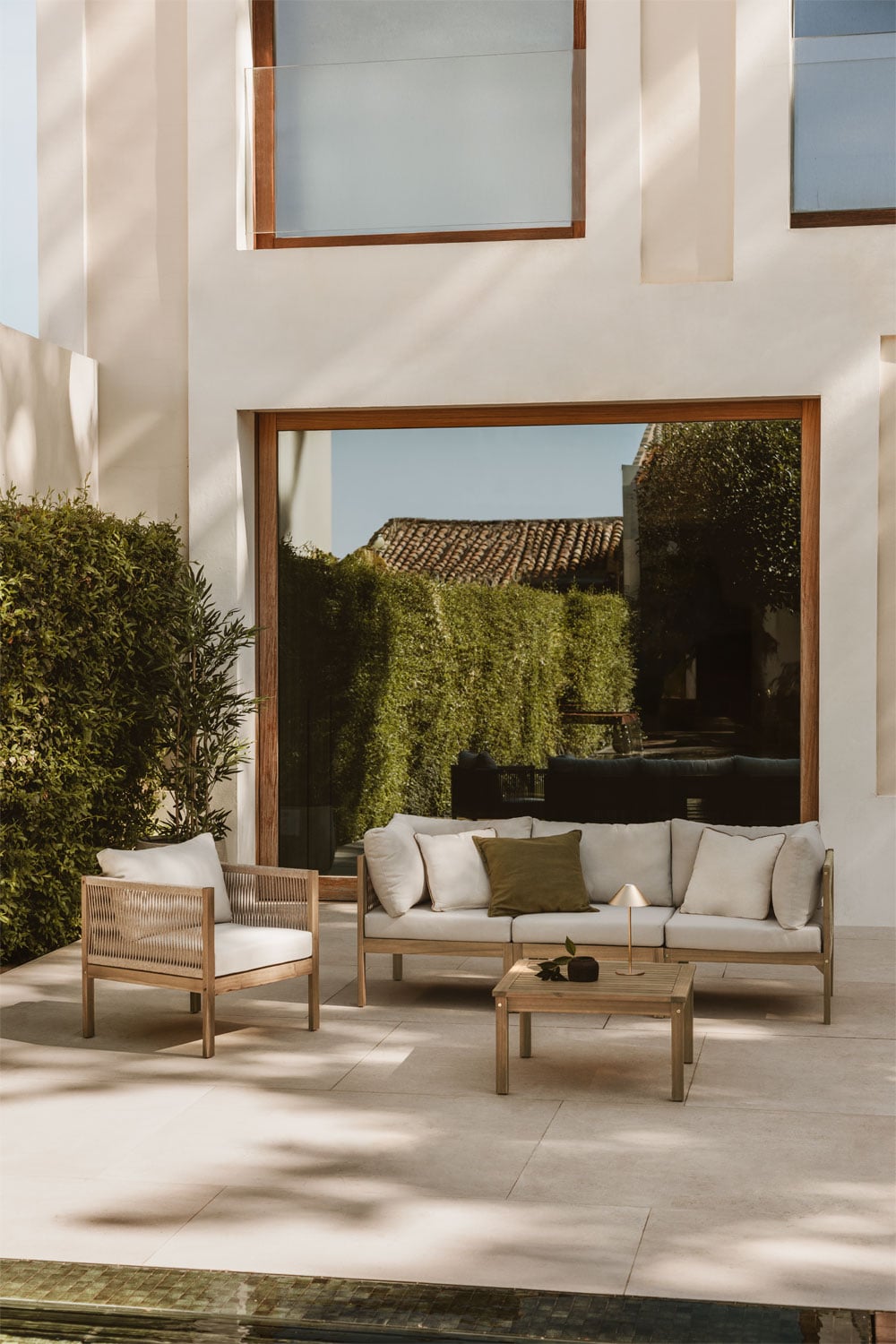 Conjunto de exterior de madera clara con cojines blancos