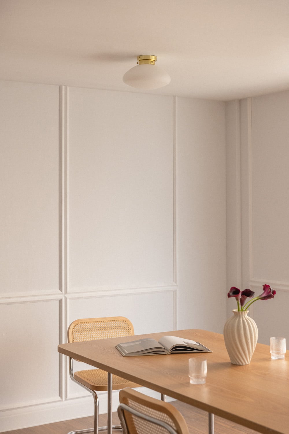 Mesa de comedor rectangular de madera clara y sillas de ratán