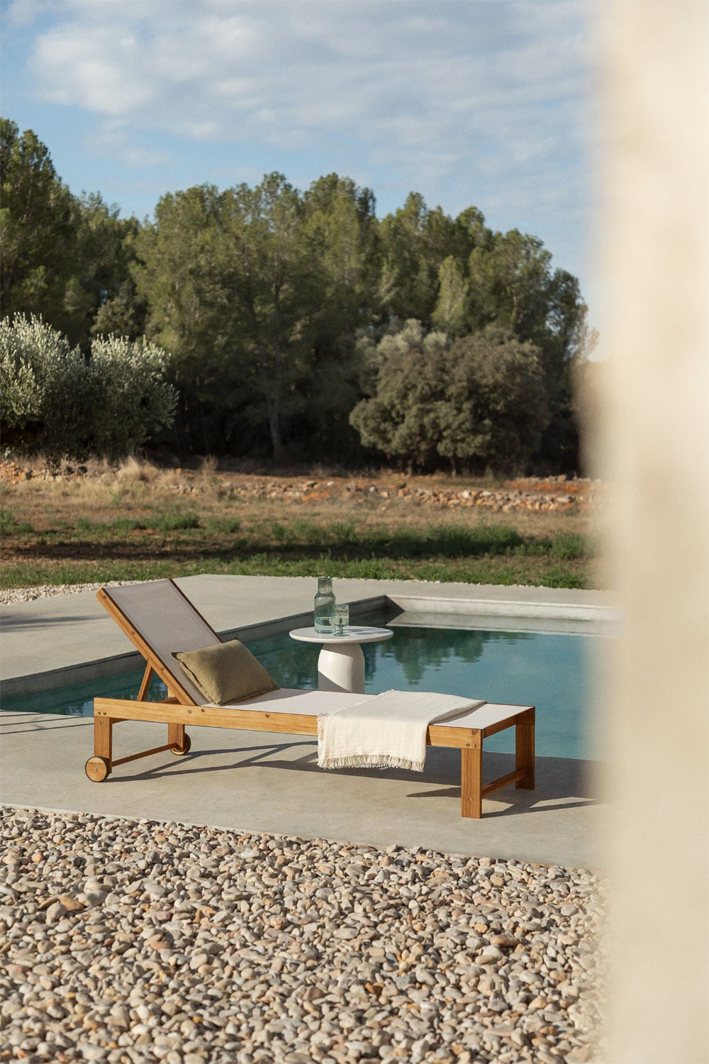 Tumbona de madera clara con cojín