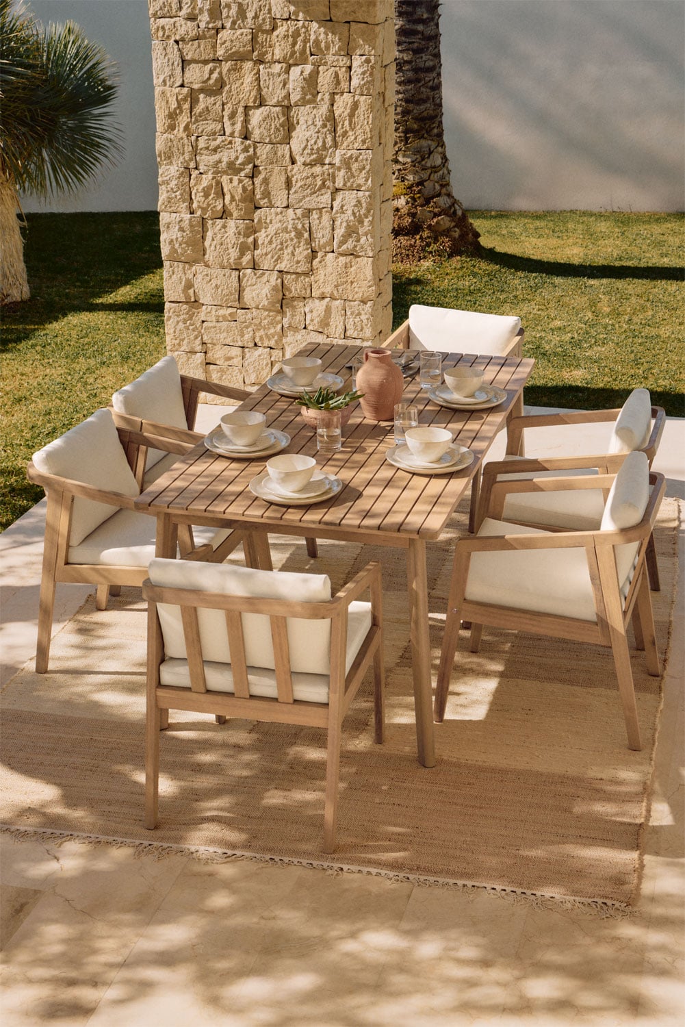 Conjunto de comedor de madera clara con sillas y cojines blancos