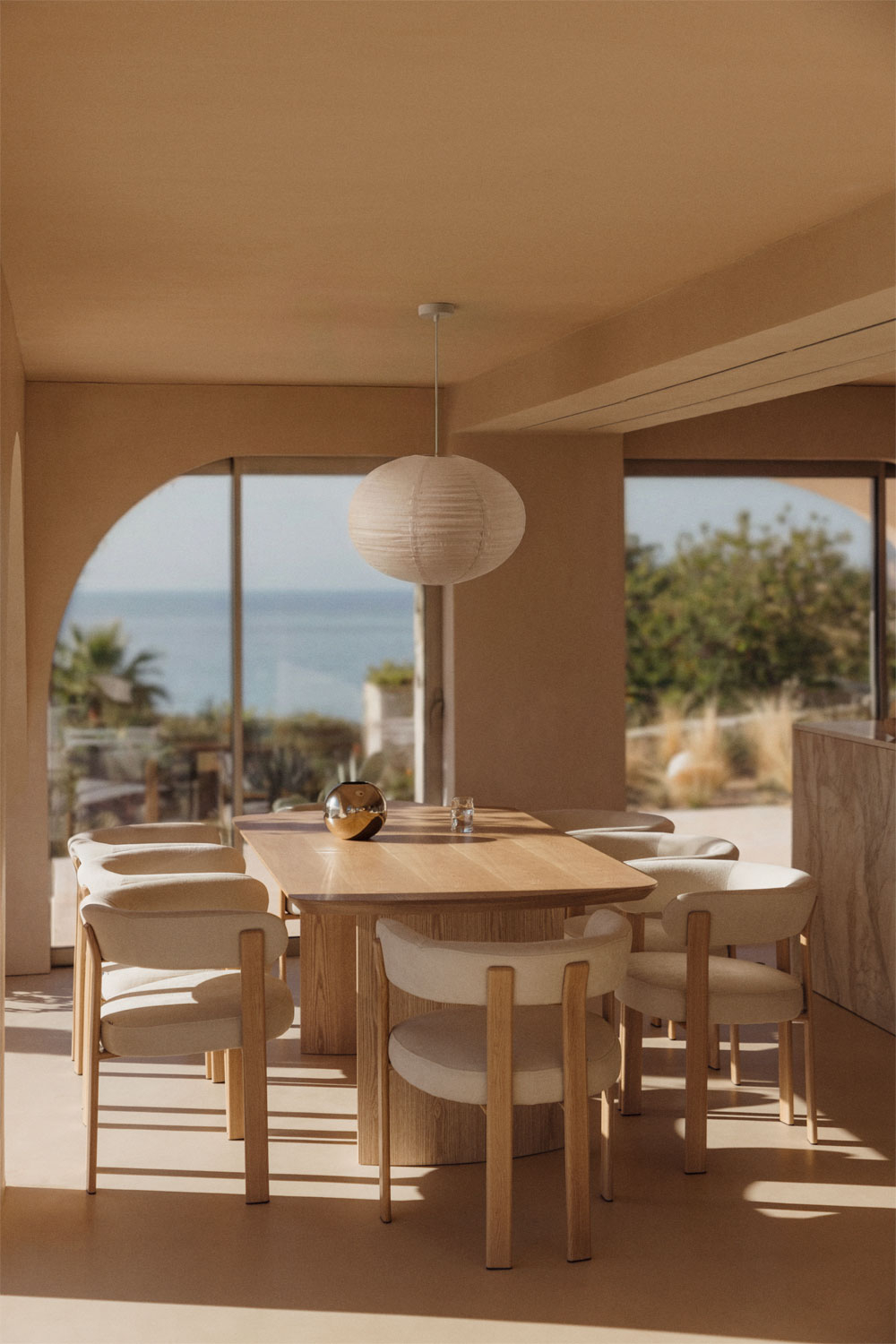 Mesa de comedor rectangular de madera clara con sillas tapizadas