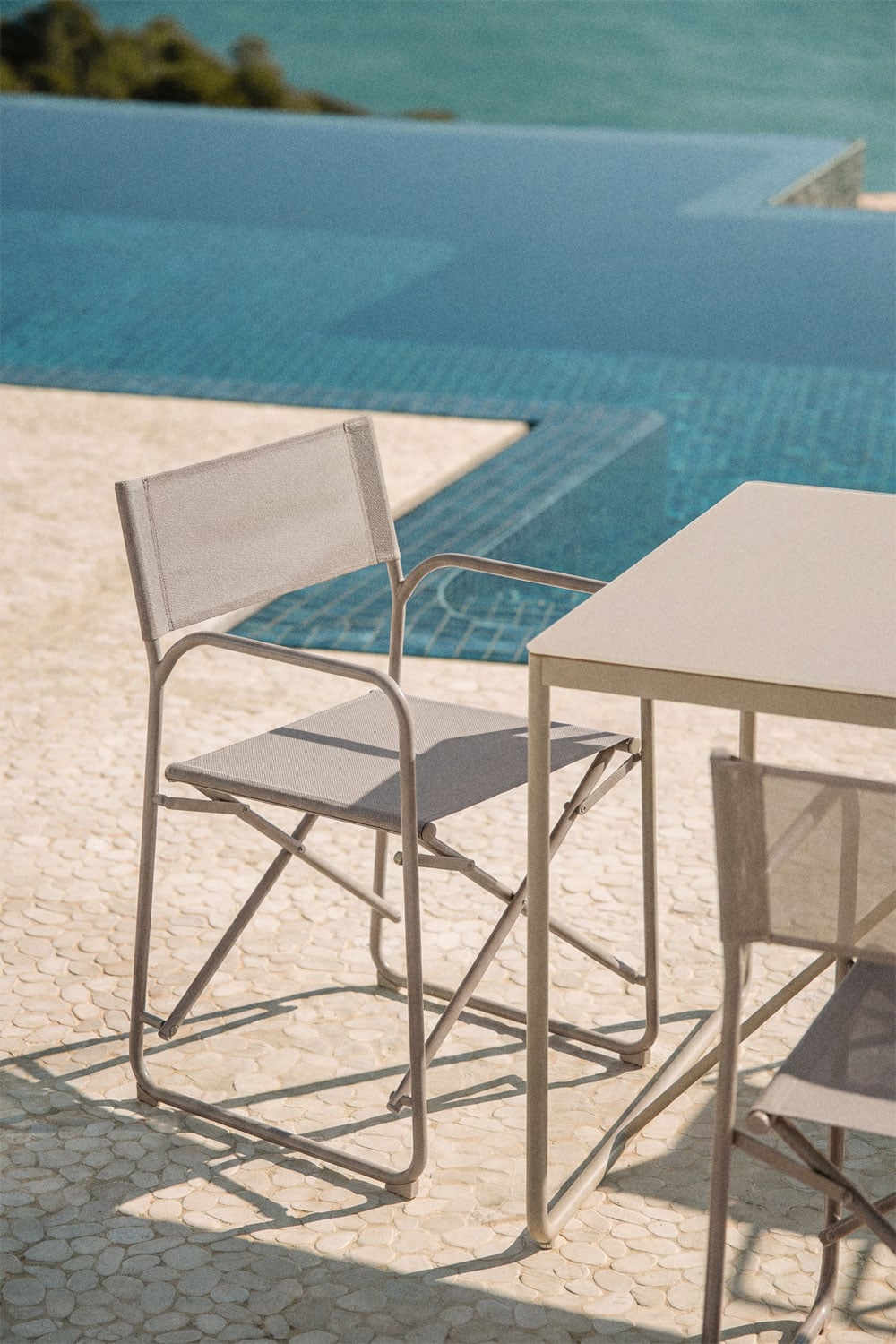 Silla de exterior plegable gris con reposabrazos