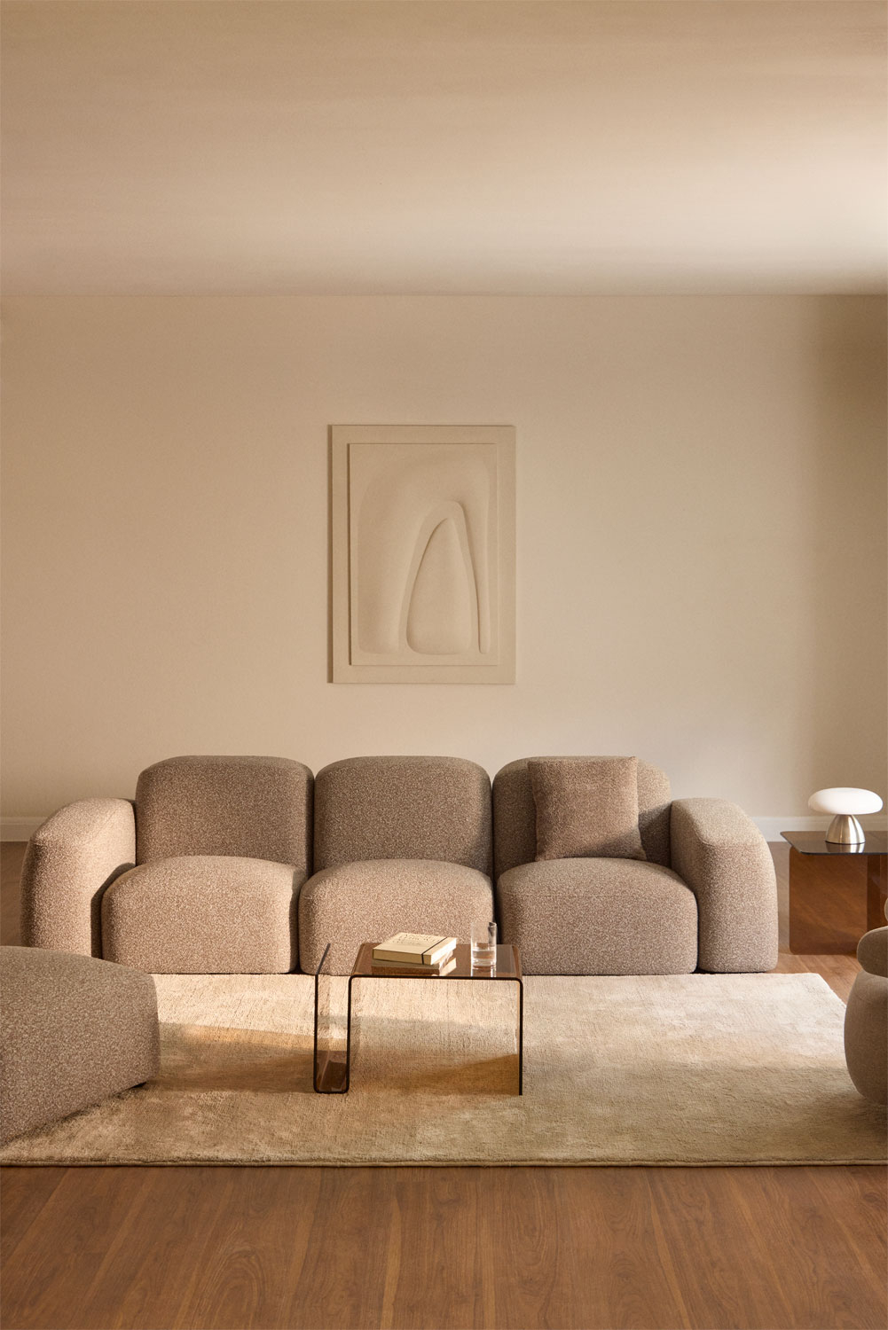 Canapé Bastian modulable en chenille beige dans un salon épuré aux lignes épurées.