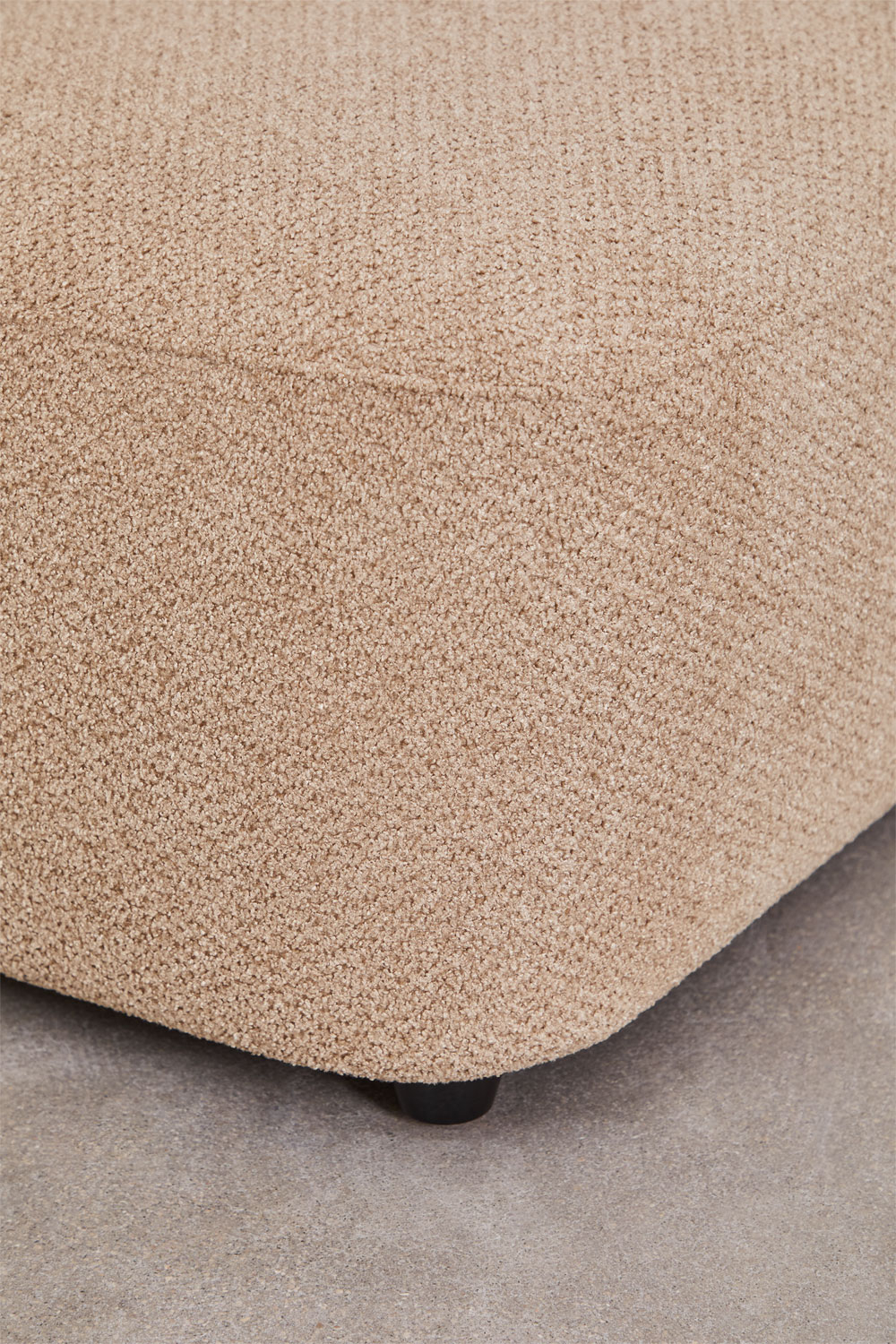 Gros plan d'un pied noir et de la chenille beige d'un élément du canapé Coco.