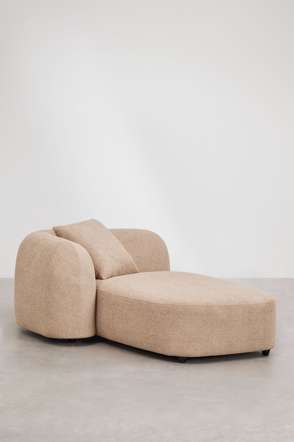 Méridienne du canapé Coco beige vue de trois quarts, avec coussin contre le dossier arrondi.