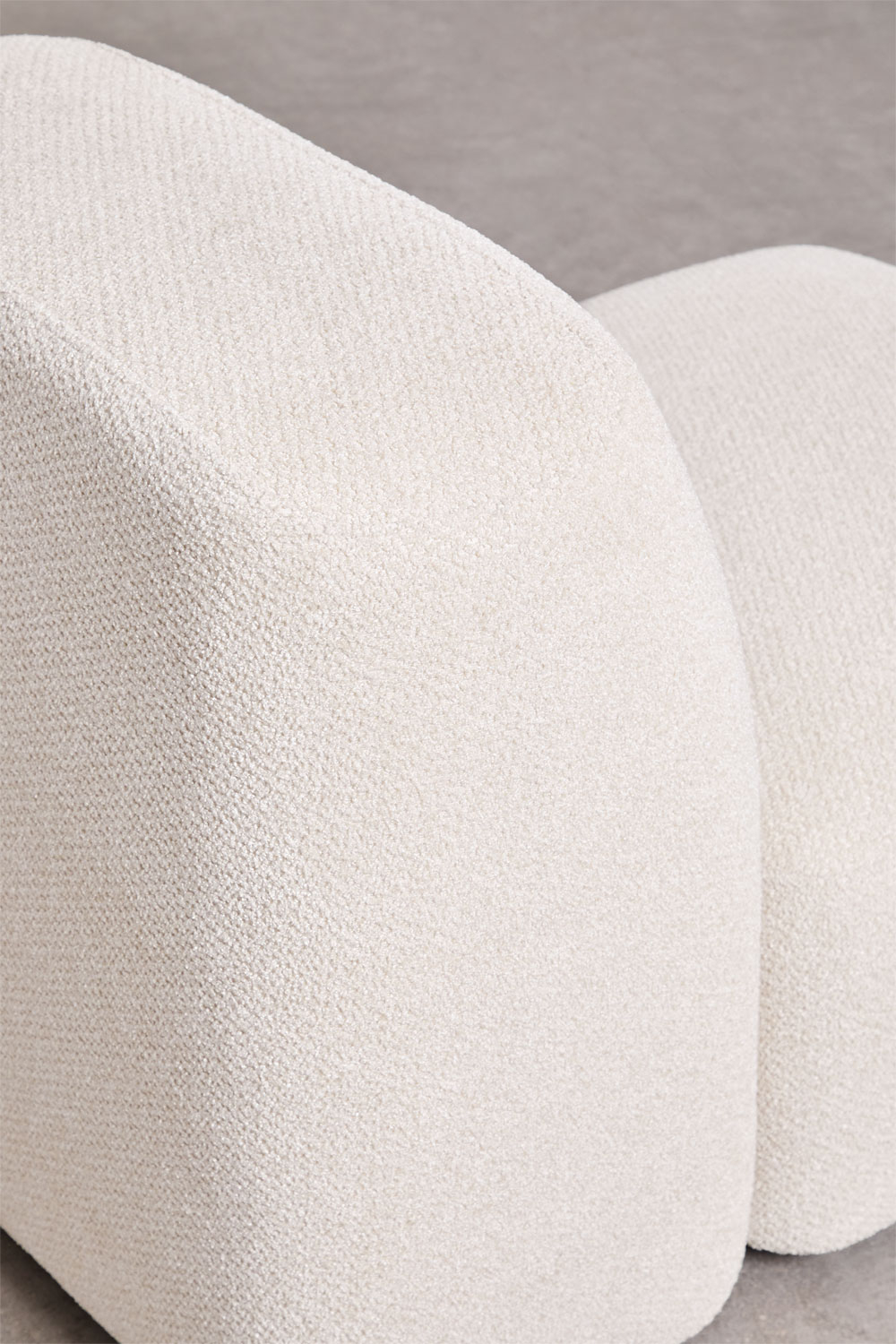 Gros plan de deux coussins arrondis du canapé Bastian en chenille blanche.
