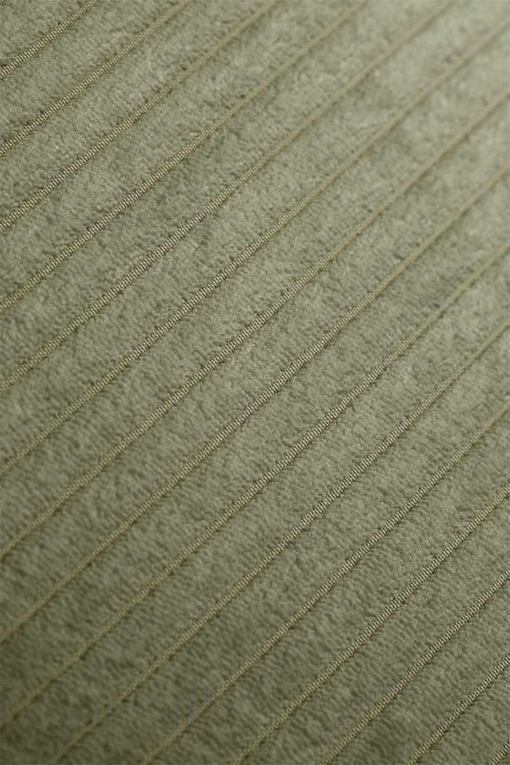Gros plan du velours côtelé vert montrant la texture et les côtes du tissu.