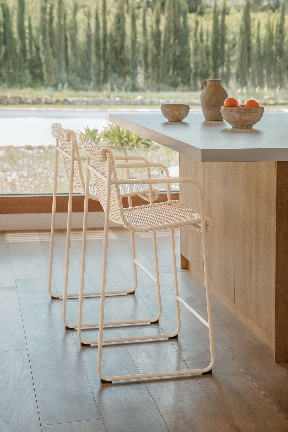 Stackable high stool with armrests in synthetic rattan and steel Revia, gallery image 1